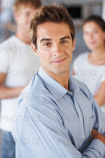 Portrait of man with coworkers in background