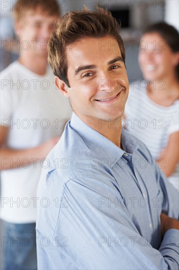 Portrait of man with coworkers in background