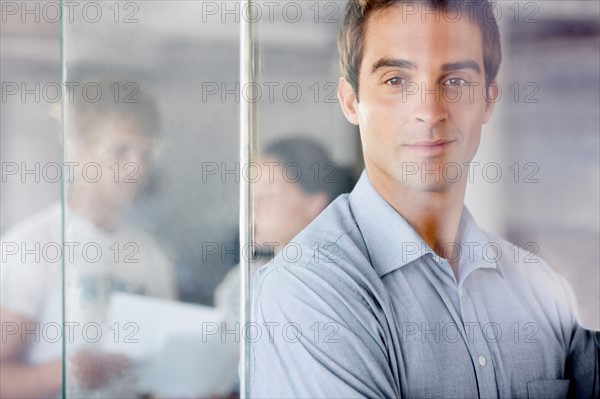 Portrait of man with coworkers in background