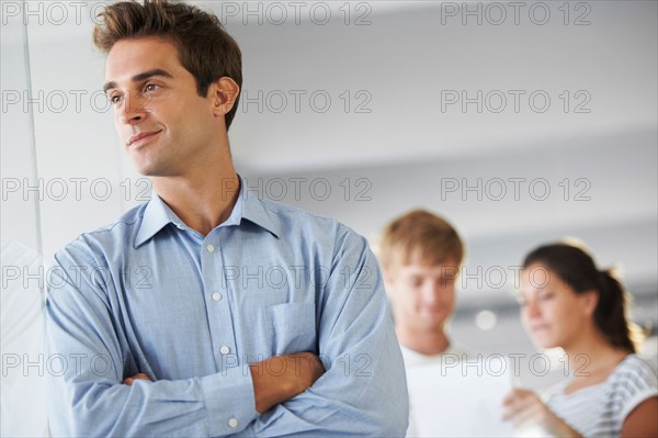 Portrait of man with coworkers in background