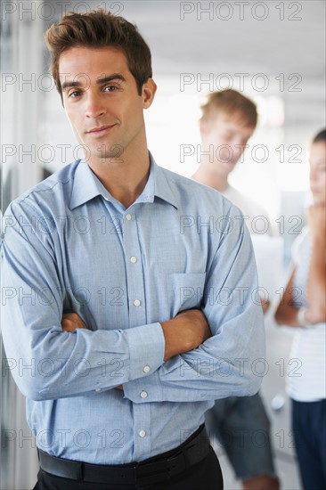 Portrait of man with coworkers in background