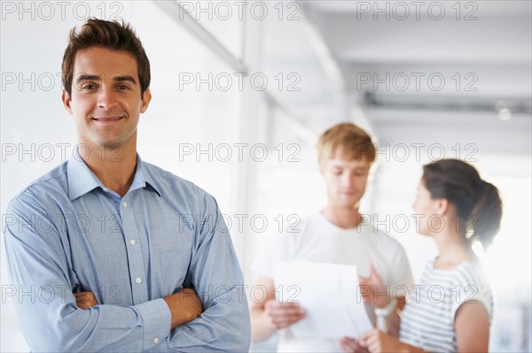 Portrait of man with coworkers in background