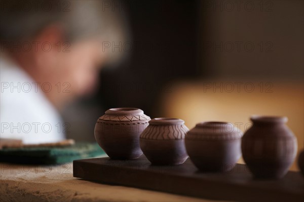 Small vases in row, man in background