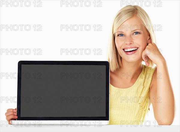 Studio portrait of young woman holding new laptop