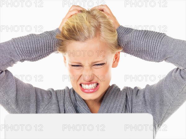 Studio portrait of young woman being frustrated in front of computer