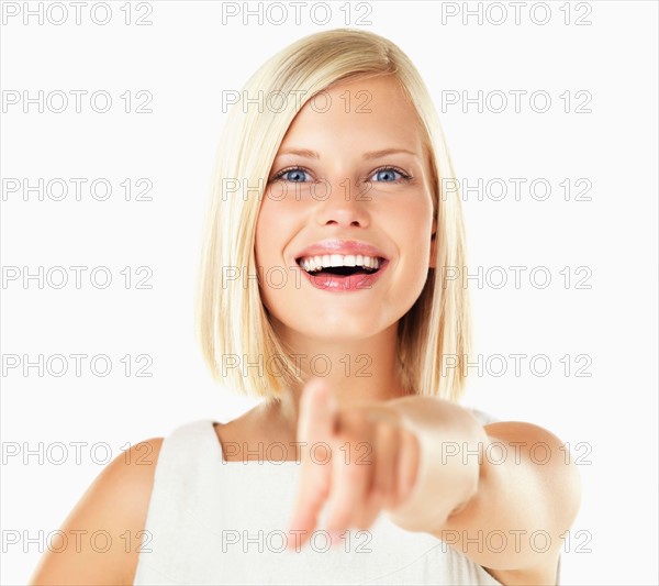 Studio portrait of young woman pointing