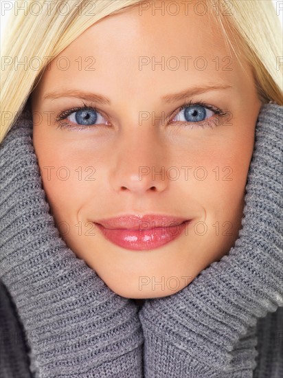 Studio portrait of young woman wearing gray sweater