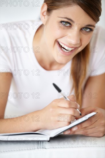 Portrait of young woman writing in notepad