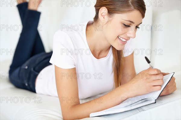 Young woman writing in notepad