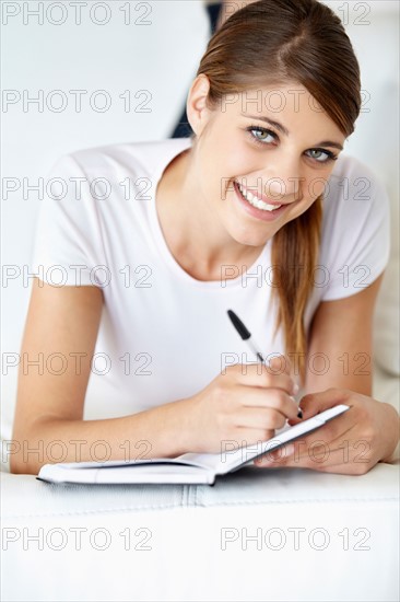 Portrait of young woman writing in notepad