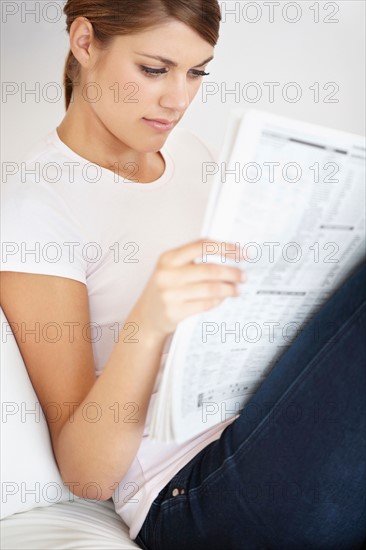 Young woman reading newspaper