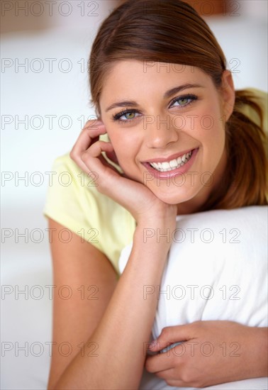 Portrait of young woman lying on bed