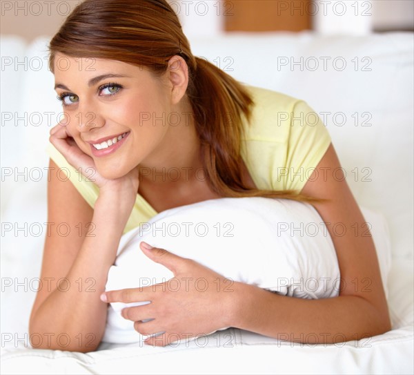 Portrait of young woman lying on bed