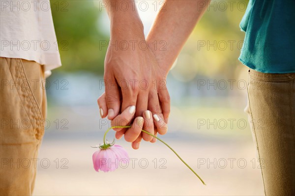 Couple holding hands and flower