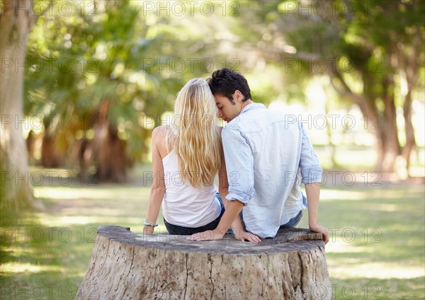 Couple sitting on tree stump