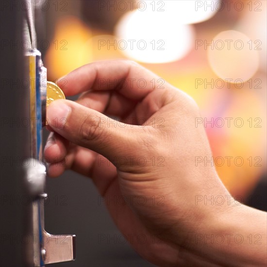 Hand inserting coin into machine