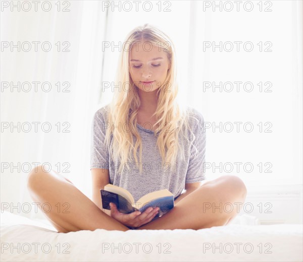 Teen (16-17) girl reading on bed