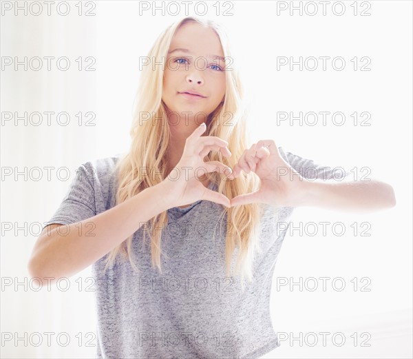 Portrait of teen (16-17) girl making heart shape with hands