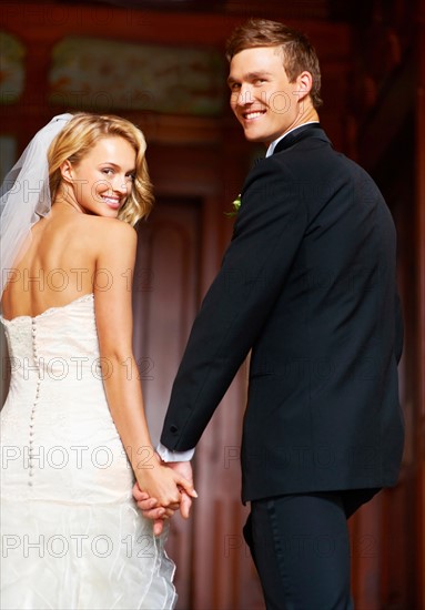 Young couple looking over shoulders towards camera