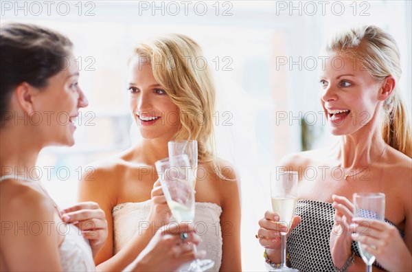 Bride and bridesmaids toasting and talking