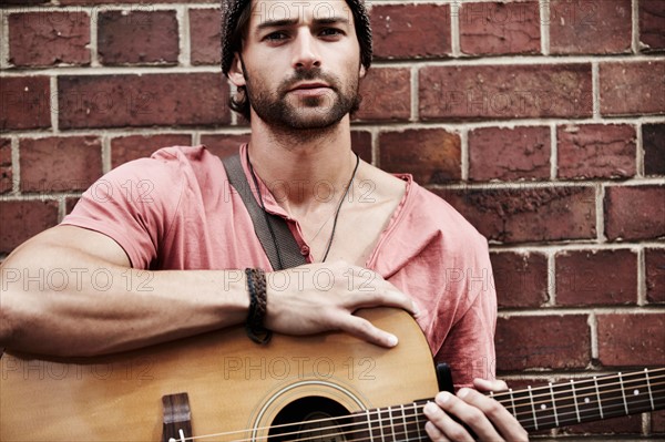 Portrait of musician against brick wall