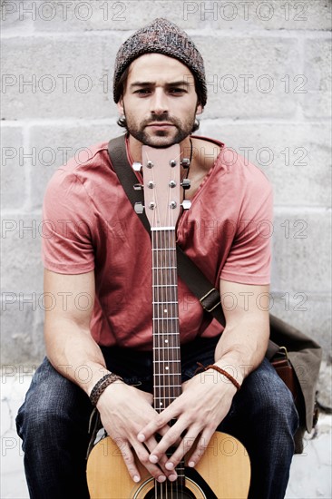 Portrait of musician against brick wall