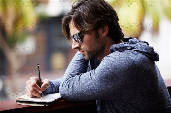 Man in sunglasses writing dirty