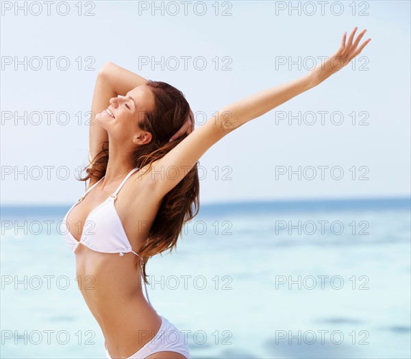 Young woman in bikini, arms outstretched