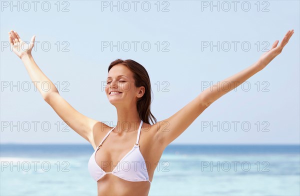 Young woman in bikini, arms outstretched