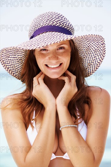 Portrait of young woman in bikini and straw hat