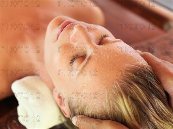 Mid adult woman receiving head massage