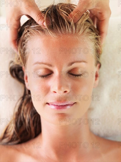 Mid adult woman receiving head massage