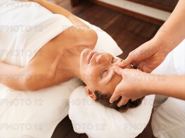 Woman getting facial massage in spa