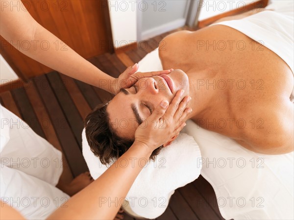 Man getting facial massage in spa