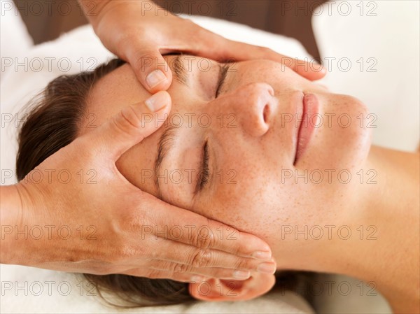 Woman getting facial massage in spa