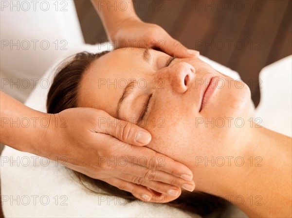 Woman getting facial massage in spa