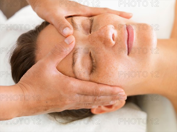 Woman getting facial massage in spa