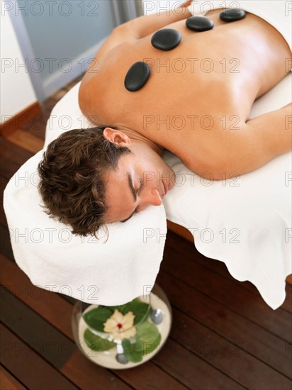 Man getting lastone therapy in spa
