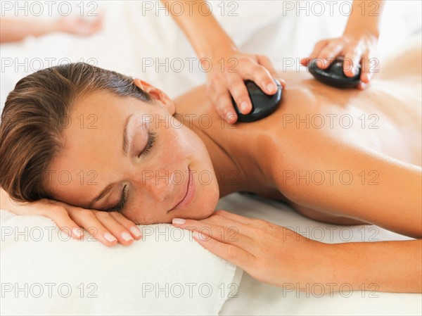 Woman relaxing while getting stone massage