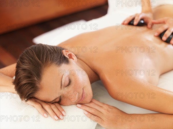 Woman relaxing while getting stone massage