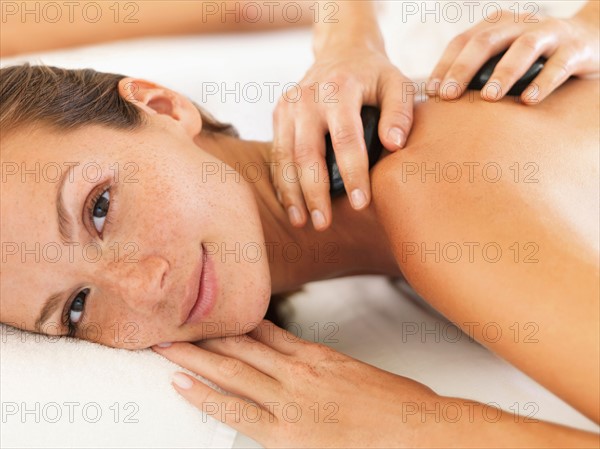 Woman relaxing while getting stone massage