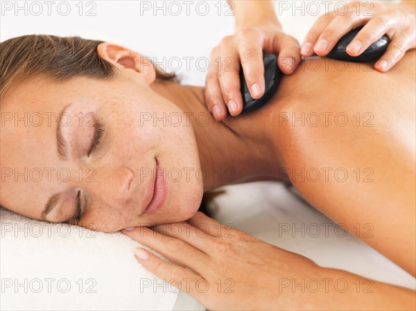 Woman relaxing while getting stone massage