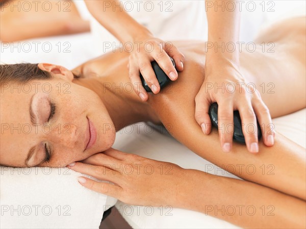 Woman relaxing while getting stone massage