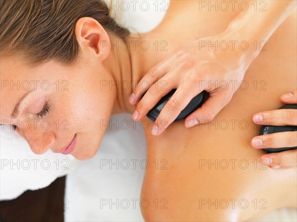 Woman relaxing while getting stone massage