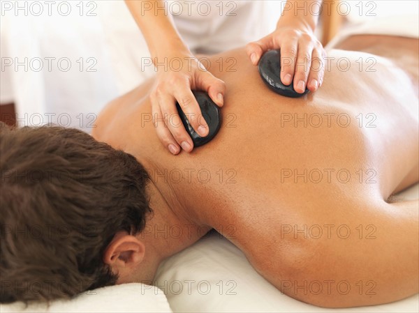 Man getting stone massage in spa