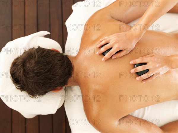 Man getting stone massage in spa