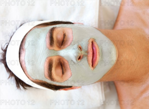 Man with face mask relaxing in spa