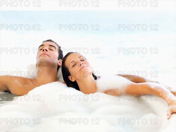 Couple relaxing in bathtub