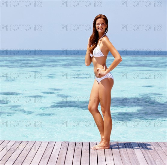 Young woman in bikini standing on jetty