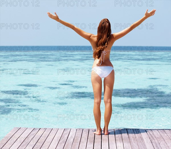 Young woman in bikini standing on jetty